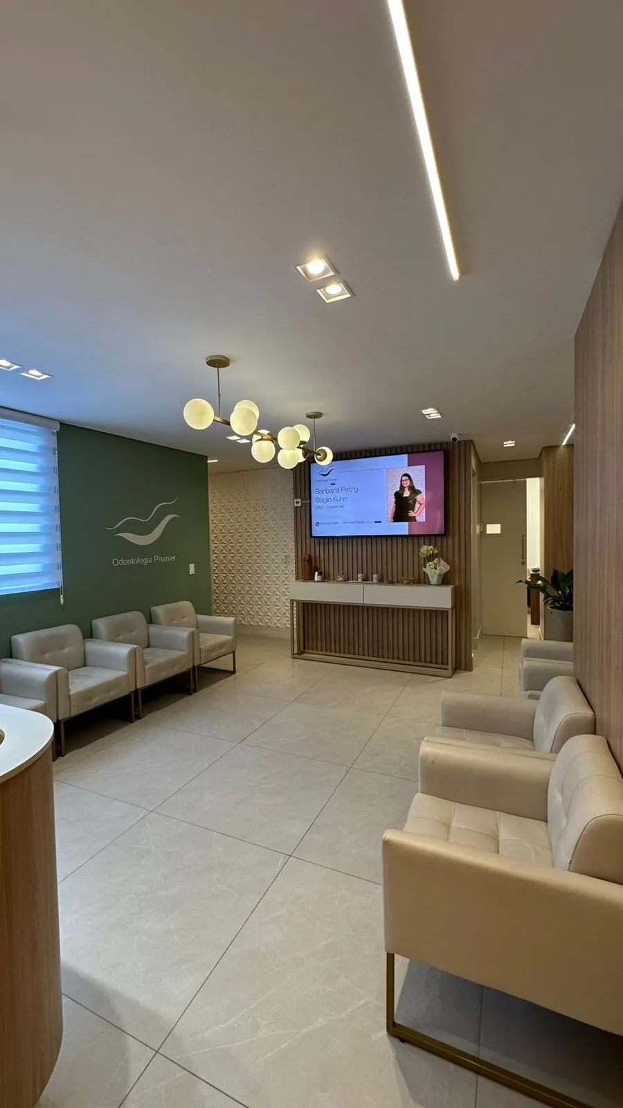 Sala de espera com o símbolo da marca na parede sálvia